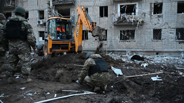 Ukrainian law enforcement officers examine debris outside a residential building damaged as a result of Russian strikes in Kharkiv on March 27. Photographer: Sergey Bobok/AFP/Getty Images