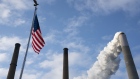 An American flag flies as emissions rise from a smoke stack at the Conesville Power Plant in Conesville, Ohio, U.S., on Saturday, April 18, 2020. The Trump administration on Thursday attacked the legal basis of requirements to capture mercury and other heavy metal pollution from power plants, setting the stage for a court to potentially toss out the mandates altogether. Photographer: Dane Rhys/Bloomberg