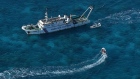A China Coast Guard vessel (upper) and China Coast Guard personnel on a rubber boat over Scarborough Shoal in the disputed South China Sea.  Photographer: Jam Sta Rosa/AFP/Getty Images